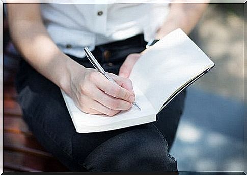 Woman writing in a book.