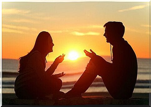 Man and woman talking on the beach.