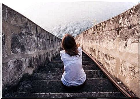 A woman sitting in front of the sea and wondering if there is such a thing as people without feelings