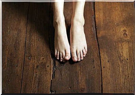 Stands barefoot on wooden floors