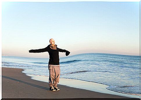 Woman with breast cancer doing relaxation exercises on the beach