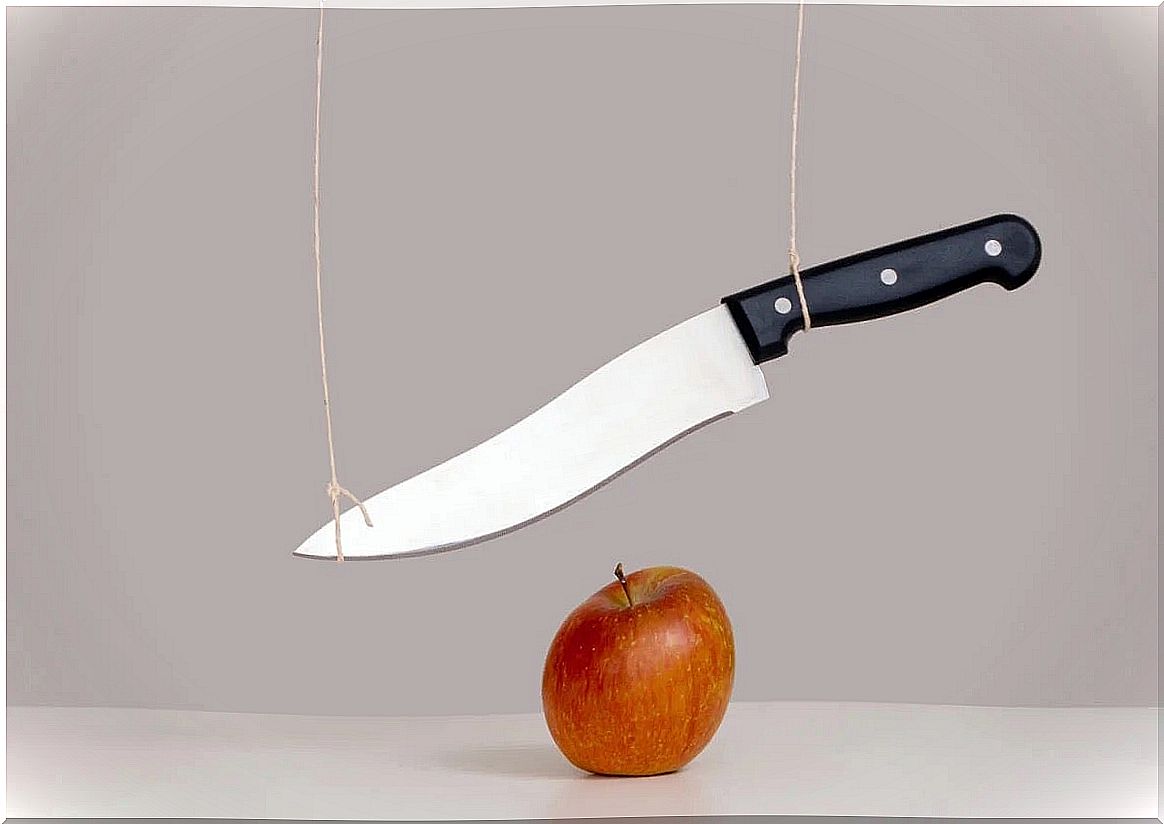 Hanging knife over apple