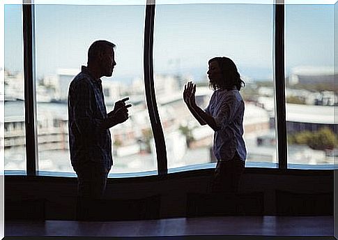 Couple arguing at window